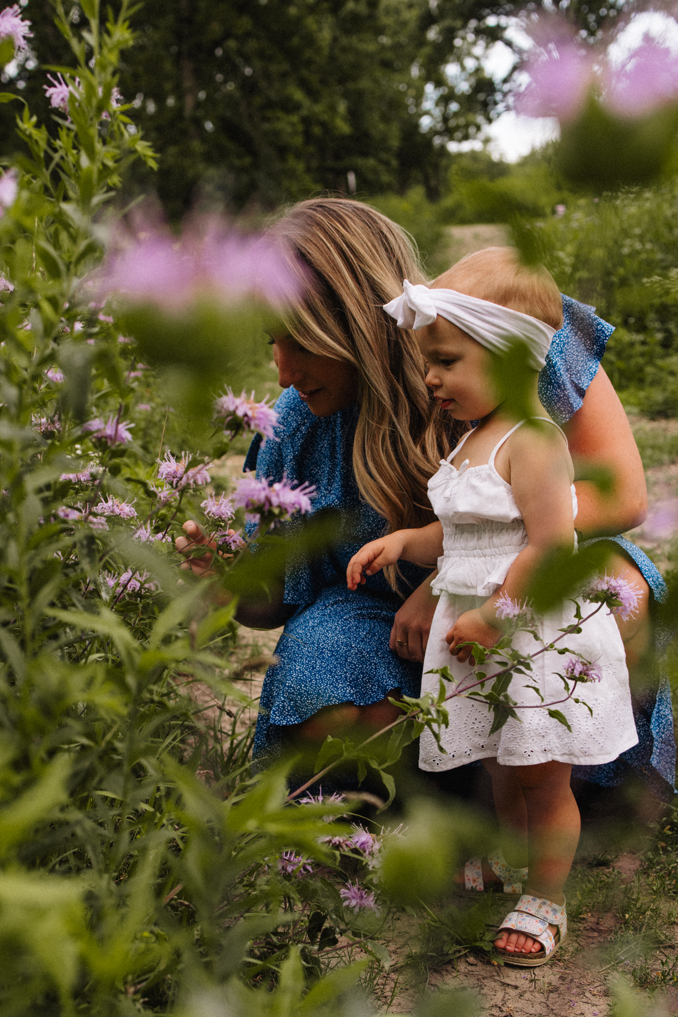 Mother and daughter smelling flowers at Morton Arboretum in Lisle, Illinois.