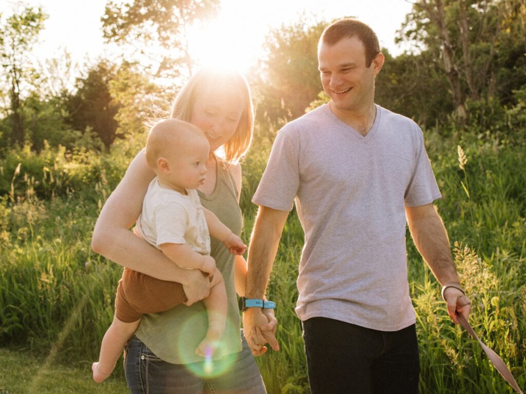 family of three walking during golden hour family photos